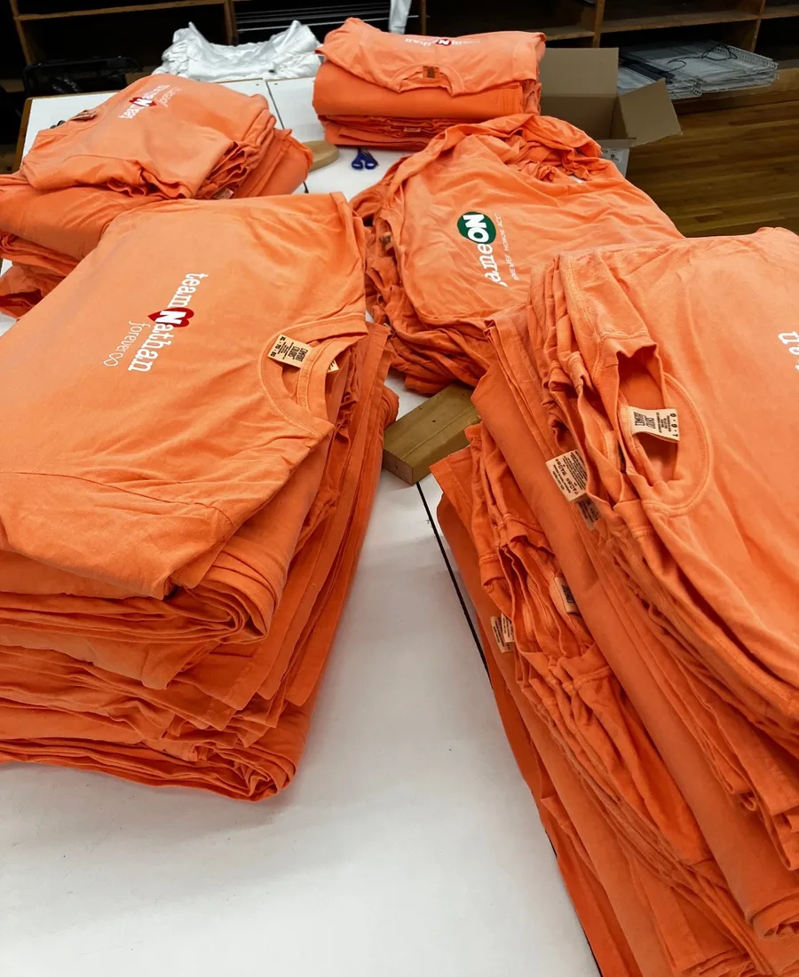 Stacks of orange team shirts
